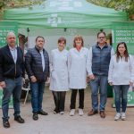 Tres hombres y tres mujeres posando delante de una carpa del Colegio Oficial de Farmacéuticos de Alicante en un parque