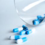 Primer plano de unas cuantas cápsulas de medicamento encima de una mesa